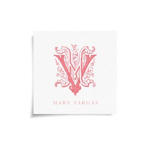 May include: A square card with a red ornate letter "V" and decorative flourishes. The name "MARY VARGAS" is printed in a serif font below the letter. The card is on a white background.