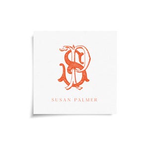 May include: Square white card with an orange monogram of the letters "SP" in an ornate, vintage style. The name "SUSAN PALMER" is printed in orange below the monogram.