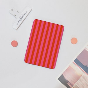 May include: A pink and red striped e-reader cover. The cover is made of a soft, durable material and is designed to protect your e-reader from scratches and bumps.