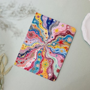 Könnte beinhalten: Ein rechteckiger, farbenfroher Kunstdruck mit einem wirbelnden Design, das von einem zentralen Punkt ausgeht. Das Kunstwerk zeigt Sterne und eine Palette aus Rosa, Blau, Gelb und Rot. Der Druck befindet sich auf einer hellen Oberfläche.