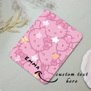 May include: Pink and white patterned phone case with a cartoon character design. The case has the name "Emma" written on it and a space for custom text.