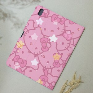 May include: Pink phone case with a repeating pattern of Hello Kitty characters and stars.