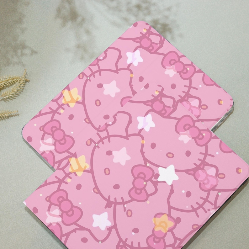 May include: Two pink laptop cases with a repeating pattern of Hello Kitty faces, stars, and bows.