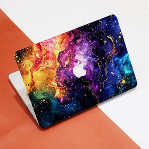 May include: A laptop computer with a colorful abstract design on the lid. The design features swirling colors of red, orange, yellow, green, blue, purple, and black with gold accents. The Apple logo is visible on the lid.