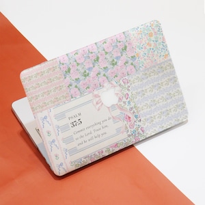 Może przedstawiać: Laptop z naklejką z kwiatowym wzorem. Naklejka zawiera cytat z Psalmu 37:5: "Poleć Panu swoje drogi, zaufaj Mu, a On sam wszystko uczyni."