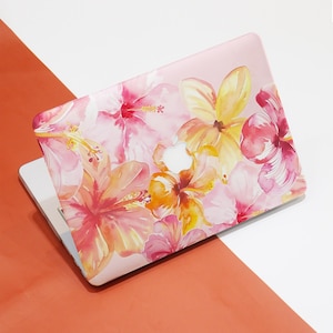 May include: A pink laptop skin with a watercolor design of pink, yellow, and orange hibiscus flowers.