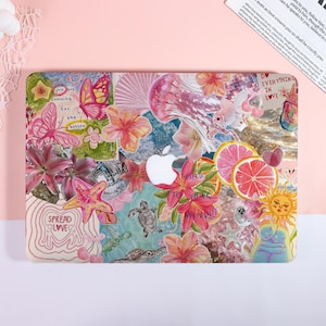Könnte beinhalten: Eine dekorative Laptop-Hülle mit einer Collage aus farbenfrohen Illustrationen. Das Design umfasst Schmetterlinge, Blumen, Meereskreaturen und Text mit der Aufschrift "Spread Love" und "Do Everything in Love". Die Hülle hat ein weißes Apple-Logo.