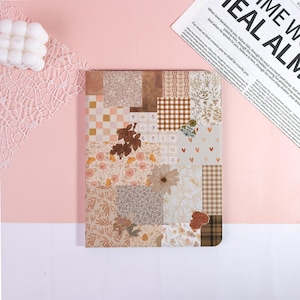 May include: A notebook with a patchwork design in brown, beige, and cream. The cover features floral, checkered, and patterned squares. The text on the side reads "ME W EAL ALM".