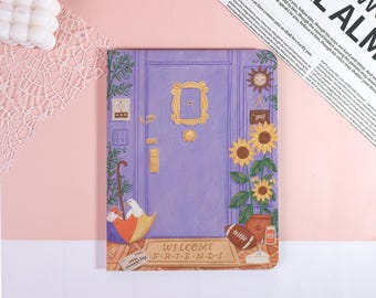 May include: A notebook featuring a purple door design with a gold frame and sunflowers. The notebook has a doormat that says "WELCOME FRIENDS". An umbrella, a football, and a dove are also depicted.