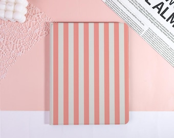May include: A rectangular notebook featuring a vertical striped pattern in alternating shades of soft coral pink and off-white. The cover has a smooth, matte finish and is positioned centrally, displaying a clean, uniform design across its surface.