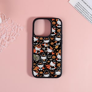 May include: Black phone case featuring a repeating pattern of Hello Kitty characters dressed in Halloween costumes. The design includes witches, bats, pumpkins, and other spooky elements. The case has a black border and is designed for a smartphone.