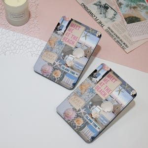 May include: Two blue and white patterned covers for an e-reader. The covers feature a collage of images including seashells, a beach scene, and the text "Meet me at the beach." and "Island Time Ave."