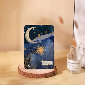 Könnte beinhalten: Eine blaue und goldene illustrierte Handyhülle mit einer Sichelmond, Sternen und einer Sonne. Der Text auf der Hülle lautet "Ich bin mit Laternen unterwegs, um mich selbst zu finden."