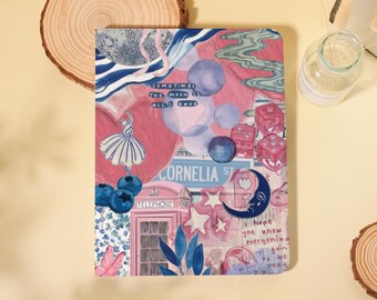 May include: A rectangular notebook cover featuring a collage of pink and blue illustrations, including a pink telephone booth, a ballerina, dice, blueberries, and a crescent moon. Text reads: Sometimes the moon is all I have and I hope you know everything is going to be okay.