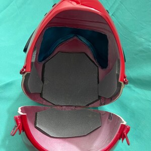 May include: Red helmet with a black trim and a gray interior lining. The helmet is open and the interior is visible.