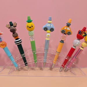 Des stylos à bille AMUSANTS pour vous faire sourire ! Mettez un peu de joie dans votre vie avec l'un de ces stylos : plage, orignal, ananas, punaises VW, enseignant.