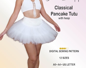 Op de afbeelding: Een wit klassiek pannenkoektutu met hoepel en een bijpassende mouwloze crop top met hoge hals, druppelvormige uitsnede en vetersluiting aan de voorzijde. De tekst luidt Bianco Incantato, Classical Pancake Tutu with hoop, DIGITAL SEWING PATTERN, 12 SIZES, A0, A4, US LETTER, PREMIUM BUNDLE: ALL 12 SIZES, US 4-22, EU 34-52, UK 2-20, BI-P013.