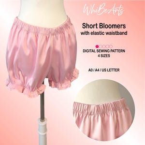 Peut inclure: Shorts bloomers roses avec une taille élastique et des bords à volants. L'image comprend le texte "Short Bloomers with elastic waistband" et "DIGITAL SEWING PATTERN 4 SIZES". Les bloomers sont présentés sur un mannequin.