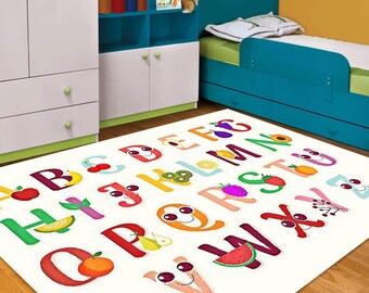 May include: A white rectangular rug with the alphabet, each letter designed with a fruit or vegetable. The letters are in various colors, including red, yellow, green, and purple. The rug is in a child's bedroom.