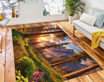 Op de afbeelding: Een kleurrijk tapijt met een landschappelijk ontwerp met een bos, bergen en een zonsondergang. Het tapijt heeft een groen, bruin en geel kleurenschema met paarse bloemen.