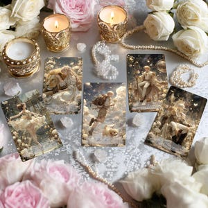 Pode incluir: Uma composição com cartas de tarot com ilustrações de fantasia, rodeadas por velas acesas em suportes ornamentados, pérolas e rosas. As cartas retratam figuras e cenas com títulos como "Força" e "O Louco". A paleta de cores é suave, com tons dourados, brancos e rosas.