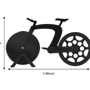Puede incluir: Cortador de pizza negro con forma de bicicleta. El cortador mide 19 cm de largo y 10 cm de alto. La rueda delantera es una cuchilla circular, y la rueda trasera tiene un dise&ntilde;o decorativo de radios. El manillar y el asiento son visibles.