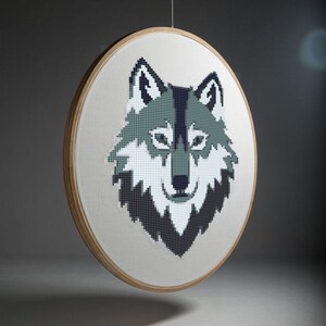May include: A gray and white wolf head embroidered on a white canvas, framed in a natural wood hoop.