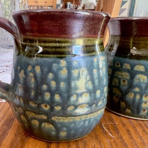 Pair of handcrafted stoneware studio pottery mugs with  multi-layered glaze signed with unidentified makers mark.