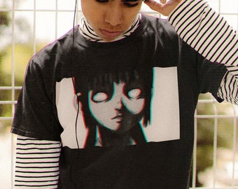 May include: A person wearing a black t-shirt with a graphic of a girl's face on it. The shirt is layered over a white and black striped long-sleeve shirt. The person is wearing blue jeans and has headphones on.