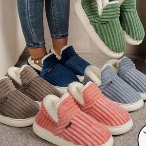 May include: A variety of corduroy slipper boots in shades of brown, blue, green, pink, and gray. Each slipper has a white sole and a plush, white interior. The boots are designed for indoor wear.