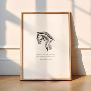 May include: A framed print with a monochrome sketch of a horse's head. The text reads: "The horse is made ready for the day of battle, but the victory belongs to the Lord. PROVERBS 21:31."