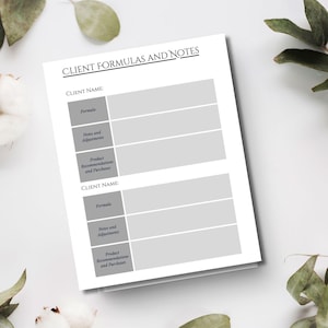 May include: A white notepad with the text "CLIENT FORMULAS AND NOTES" at the top. The notepad has sections for client name, formula, notes, adjustments, and product recommendations. The notepad is surrounded by green leaves.