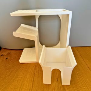 May include: White plastic organizer with three compartments. The top compartment has a small shelf, the middle compartment is open, and the bottom compartment has a removable tray.