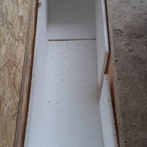 Pu&ograve; includere: Una cassa di legno aperta, rivestita con imbottitura in schiuma bianca. La cassa &egrave; rettangolare, con un esterno marrone chiaro e un interno bianco. L'imbottitura in schiuma serve a proteggere il contenuto durante la spedizione.