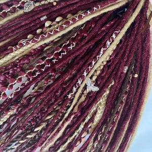 Colored dreadlocks. Braid extensions DE and SE. Synthetic dreadlocks in red tones.Wine colored hair.