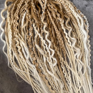 Thin double-sided synthetic dreadlocks with extensions, in beige and blond tones.