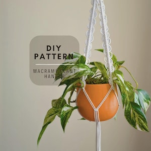 Könnte beinhalten: Ein weißer Makramee-Pflanzenhänger mit gewelltem Randdesign hält einen orangefarbenen Topf mit einer panaschierten grün-weißen Efeutute. Das Bild enthält den Text DIY PATTERN MACRAME PLANT HANGER in dunkelbrauner Schrift auf einem hellgrauen Quadrat.