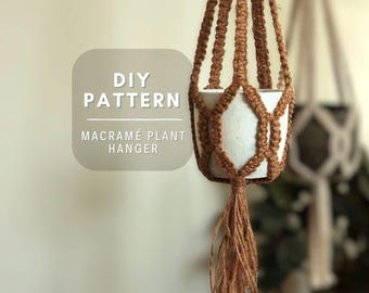 Puede incluir: Un colgador de plantas de macramé marrón con un diseño de cuerdas anudadas que sostiene una maceta cilíndrica blanca, con una borla en la parte inferior. Un gráfico gris claro muestra el texto blanco: DIY PATTERN MACRAMÉ PLANT HANGER.