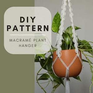 May include: A macramé plant hanger with a terracotta pot filled with green plants. The white macramé has a decorative pattern and a tassel. The image includes the text "DIY PATTERN MACRAMÉ PLANT HANGER" on a white and green background.