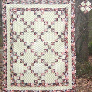 May include: A quilt with a patchwork design featuring a variety of animal faces. The quilt is made with a cream-colored fabric with a small, repeating pattern of green dots. The quilt is bordered with a red and brown fabric with a repeating pattern of animal faces.