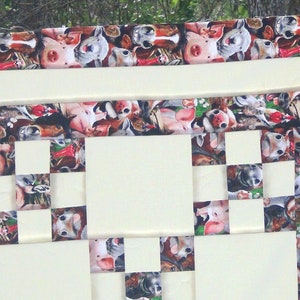 May include: A white quilt with a checkered pattern. The squares are made of fabric with a print of various farm animals, including pigs, chickens, and cows. The quilt is edged with a border of the same animal print fabric.