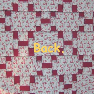 May include: A red and white patchwork quilt with a cherry print. The back of the quilt is visible with the word "Back" written on it.