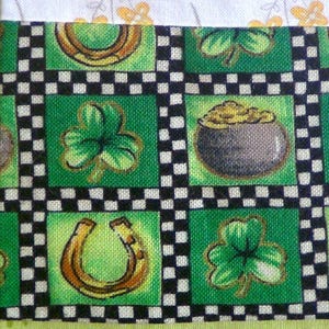 May include: Green fabric with a checkered pattern featuring shamrocks, horseshoes, and pots of gold. The fabric is perfect for crafting projects like quilts, pillows, and bags.