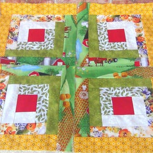May include: A yellow, green, red, and white patchwork quilt block with a farmhouse theme. The block is made up of squares and rectangles of different fabrics, including a floral print, a green print with leaves, and a red print with a barn scene. The block is surrounded by a yellow border with a small white polka dot pattern.