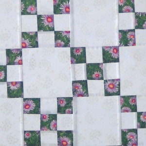 May include: A white tiled surface with a checkered pattern of purple flowers on a green background.