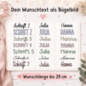 Könnte beinhalten: Ein weißes rechteckiges Blatt mit sieben verschiedenen Schriftarten, beschriftet von Schrift 1 bis Schrift 7, die jeweils die Namen Julia und Hanna zeigen. Der Text oben lautet Dein Wunschtext als Bügelbild und unten Wunschlänge bis 29 cm.