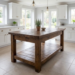 May include: A rectangular kitchen island made of dark brown wood with a thick planked top and a lower slatted shelf. The island features four sturdy square legs and a natural wood grain finish, positioned in the centre of a bright kitchen space.
