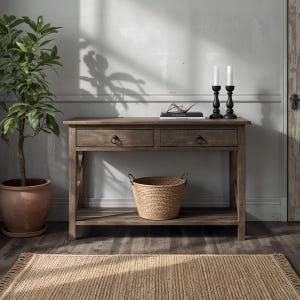 May include: A wooden console table with two drawers and a lower shelf. A woven basket sits on the shelf. Two black candle holders with white candles and a potted plant are also visible. A woven rug is on the floor.