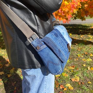 Upcycled denim messenger bag with striped design, adjustable strap, black nylon lining, and 2 interior pockets.