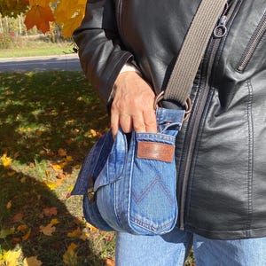 Upcycled denim messenger bag with striped design, adjustable strap, black nylon lining, and 2 interior pockets.